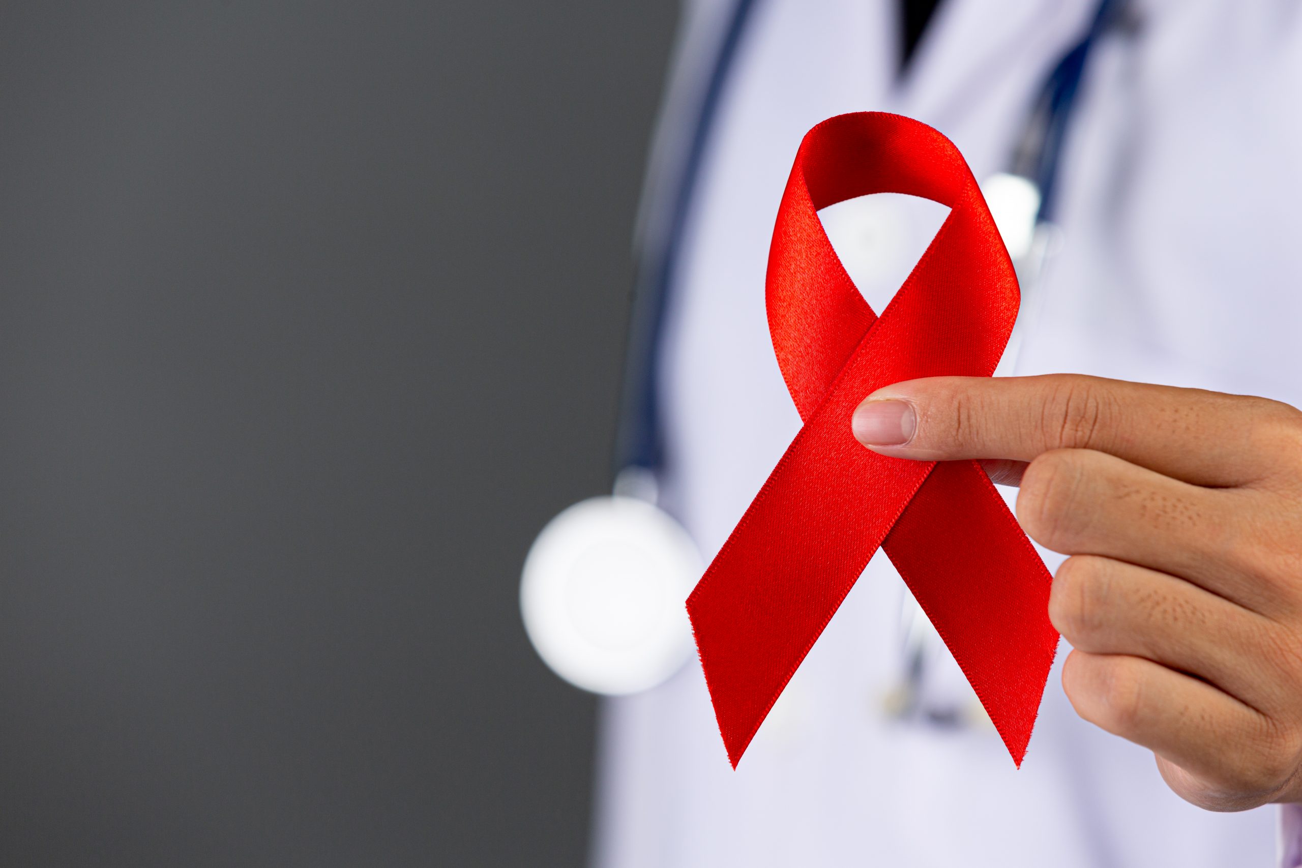 The doctor holds a red ribbon, HIV awareness awareness, World AI The doctor holds a red ribbon, HIV awareness awareness, World AIDS Day and World Sexual Health Day.